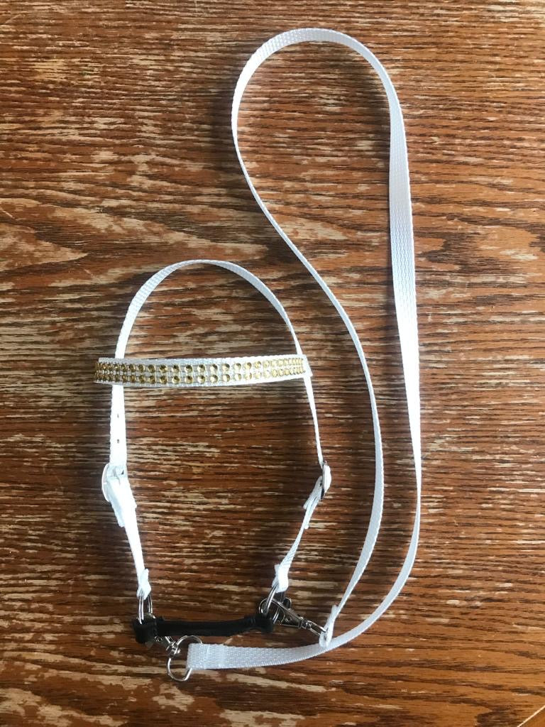 White hobby horse bridle with reins. The bridle has golden bling on the brow band