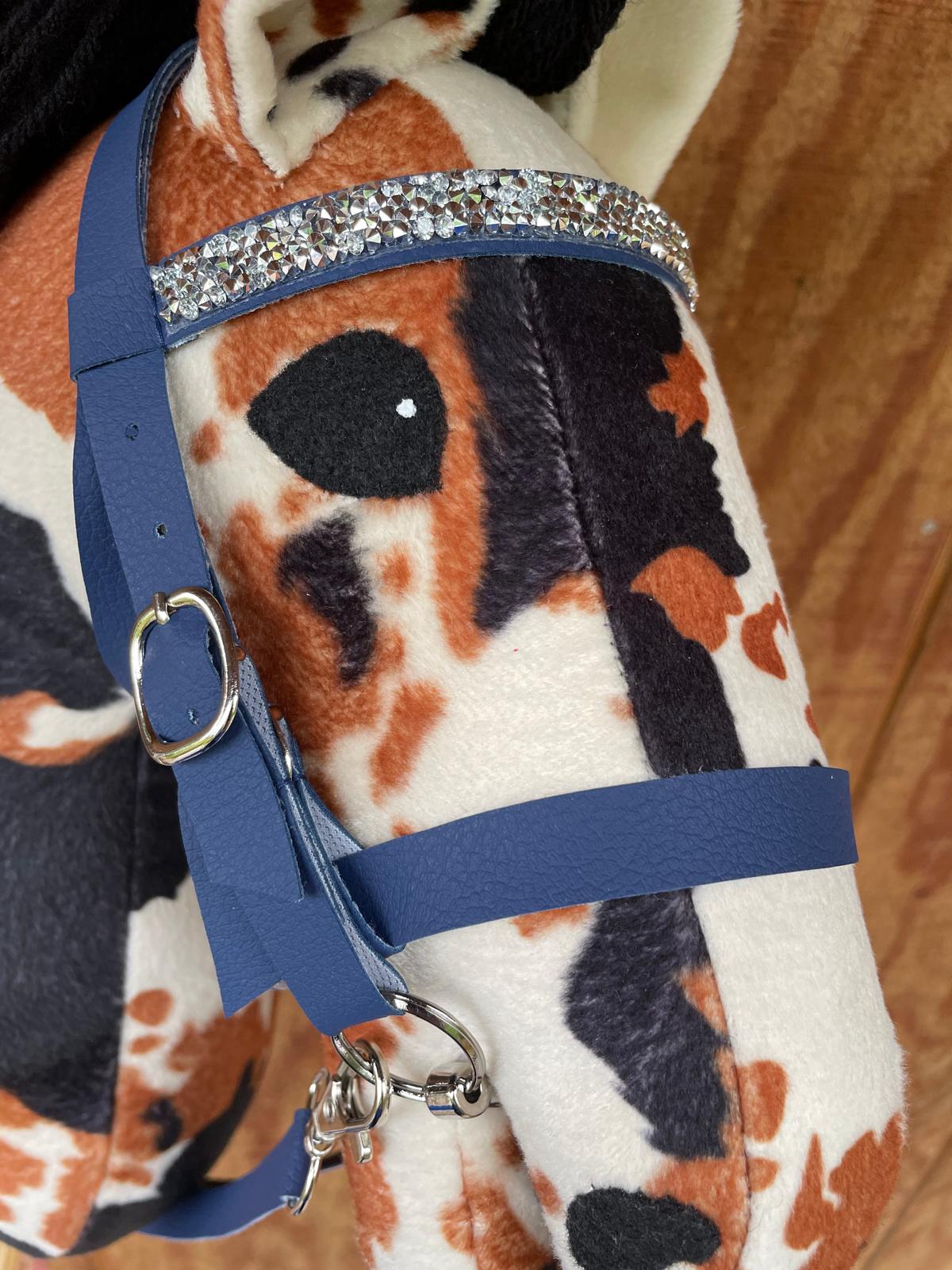 Close-up of a plush toy horse with a blue bridle and decorative elements.