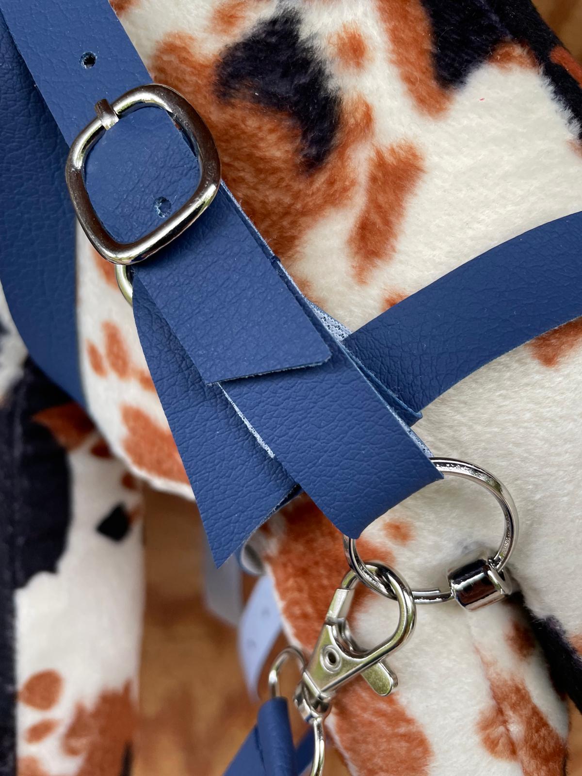 Blue leather strap with silver buckle on a patterned fabric background