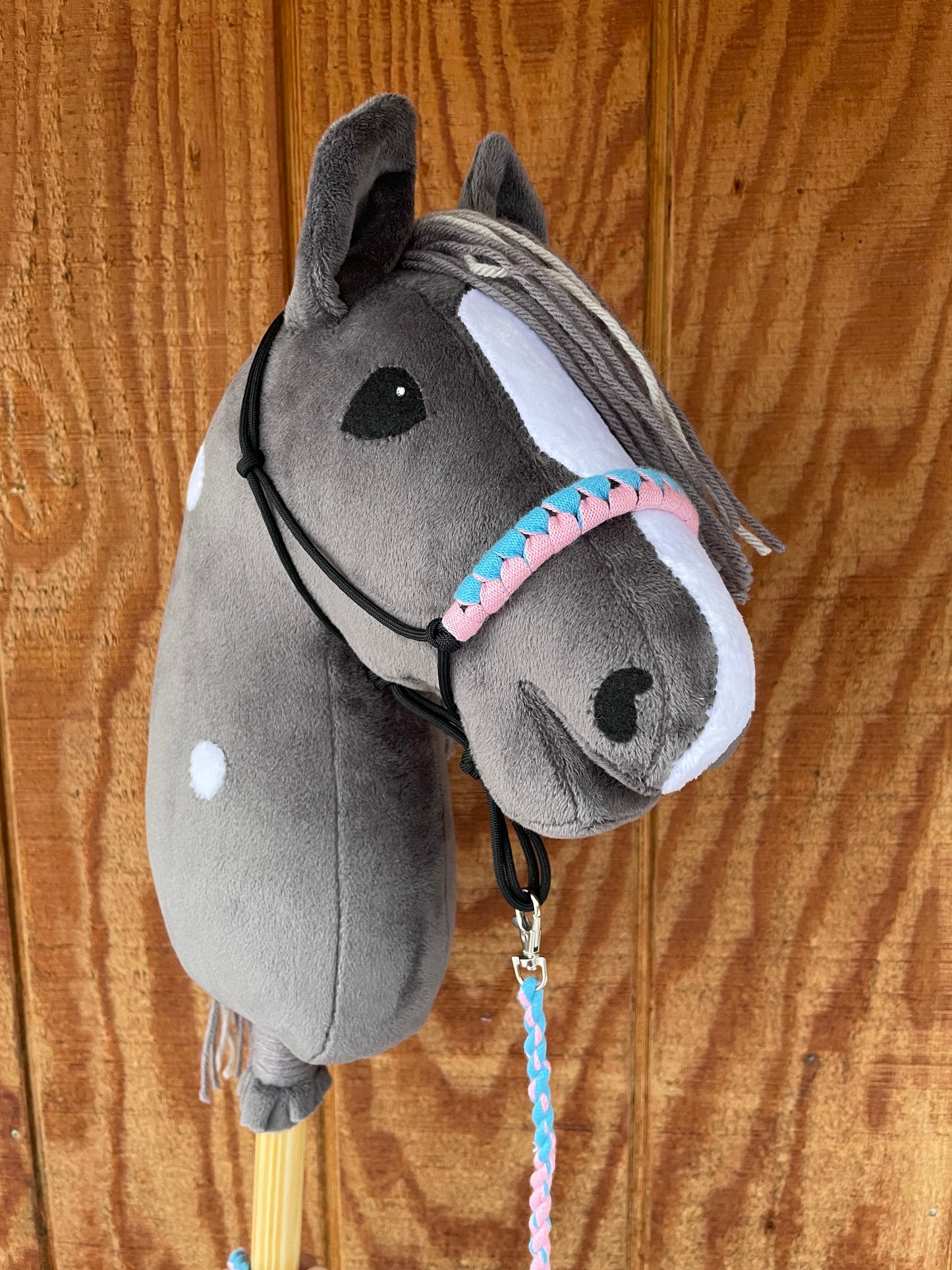 Hobby Horse dark gray with halter. Wooden Background.