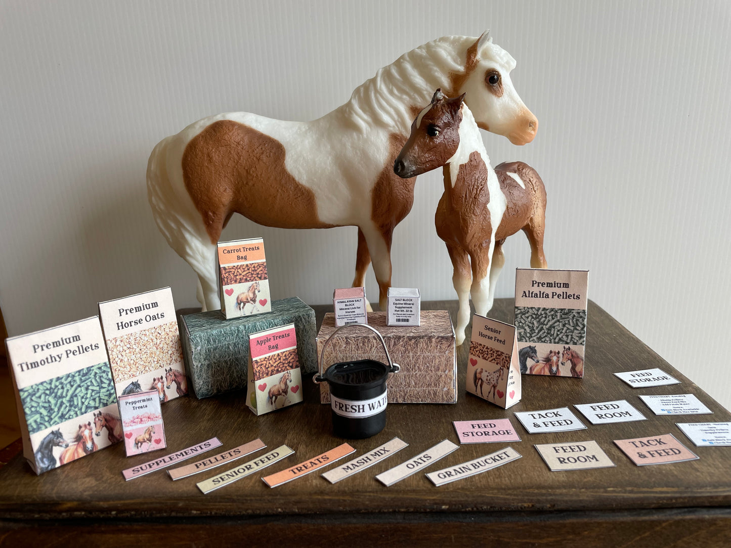 Model horse with miniature horse feed supplies on a wooden table