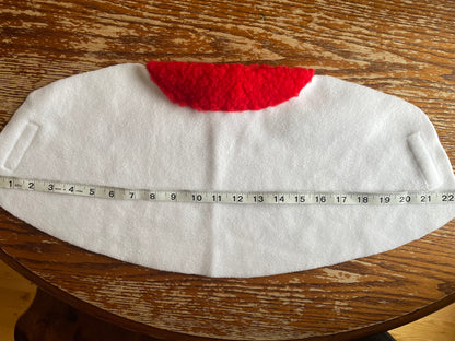 White hobby horse with a red padding on a wooden surface, measured by a tape measure.