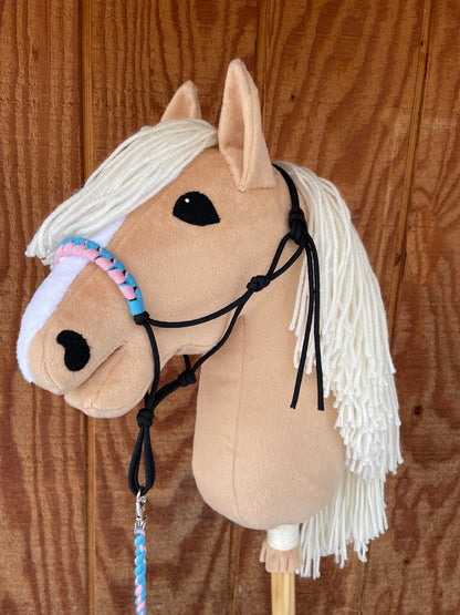 Plush hobby horse toy with a halter on a wooden surface