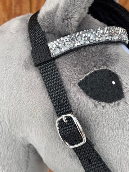 Close-up of a gray hobby horse's bridle on a wooden surface