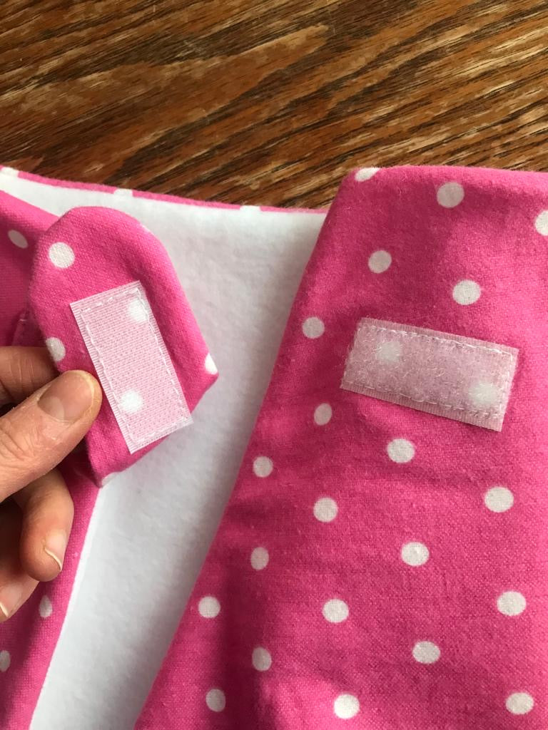 Close up picture of a hot pink/red hobby horse blanket with white dots on it 