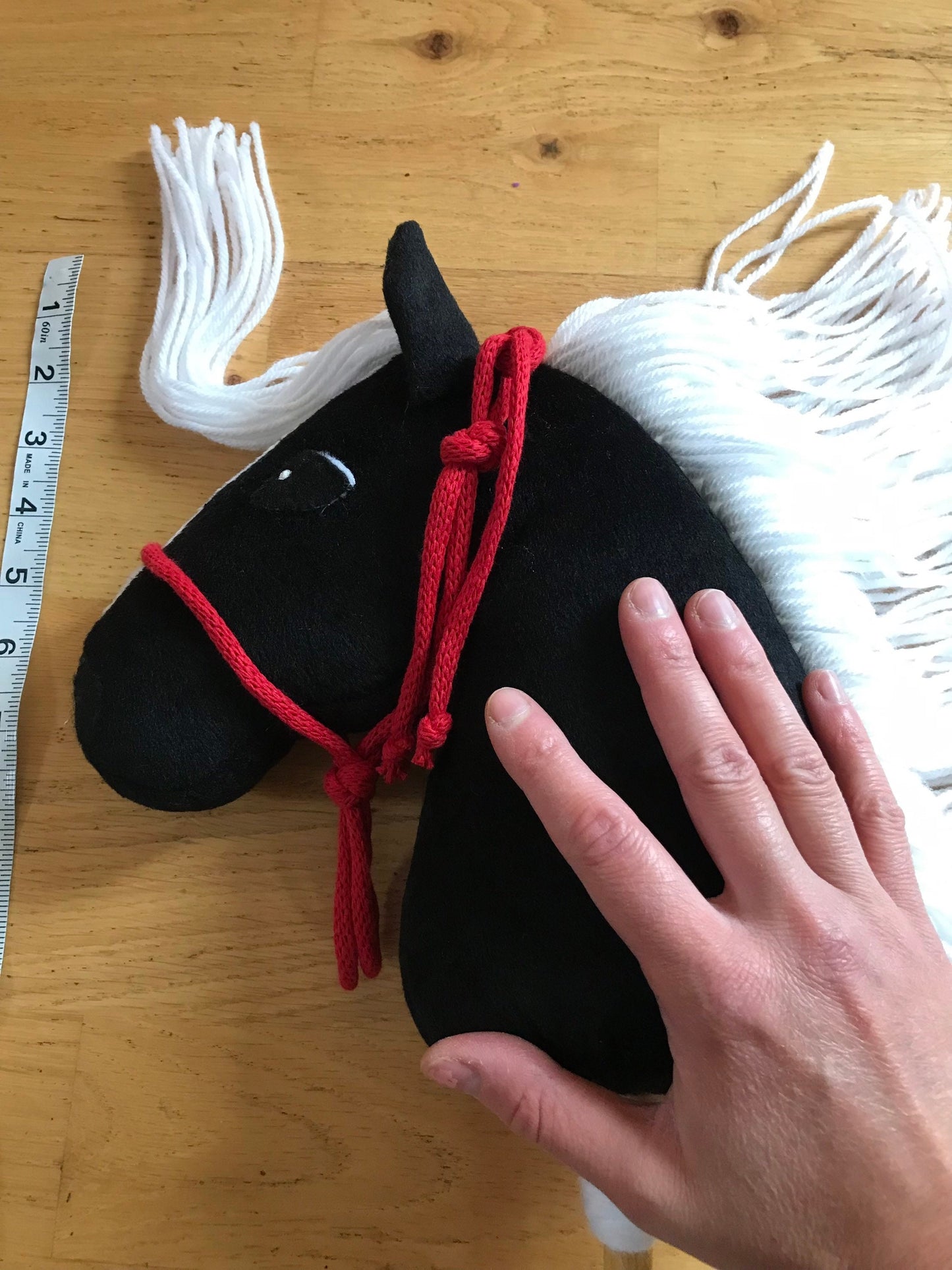 Hobby horse mini pony black, hand on a horse to show measure